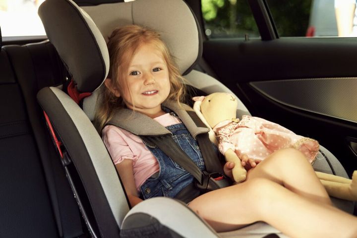 Portrait of little girl sitting in the baby car seat