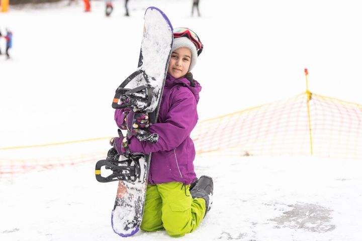 Snowboard winter sport. Cute girl with snowboard going to slide in winter nature
