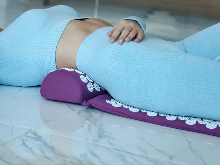 Acupressure mat massage therapy. Close-up young woman lying on orthopedic acupressure mat