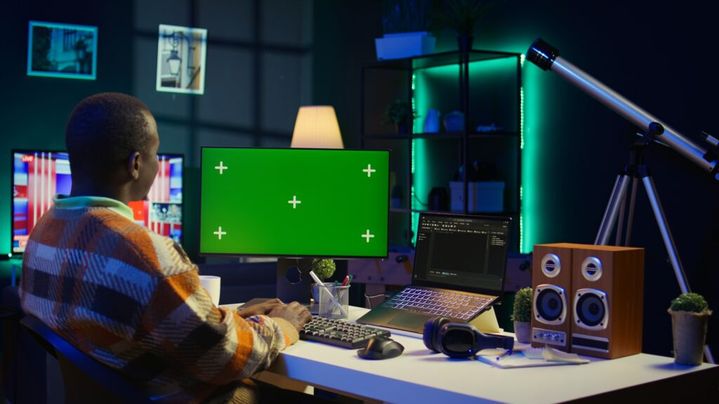 Server technician optimizing program and next to green screen