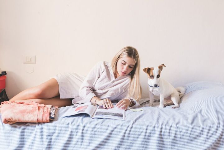 woman young lying bed with dog reading