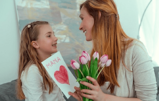 Dziewczynka wręcza kwiaty na Dzień Matki