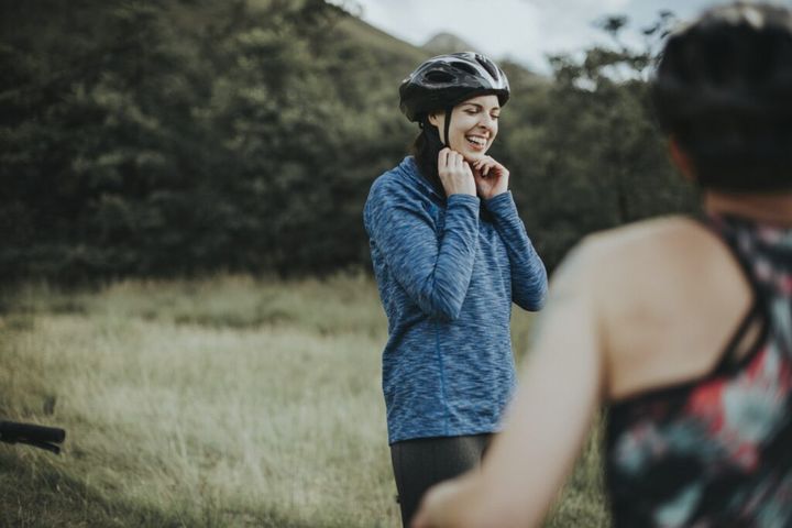 Cyclist putting on her bike helmet