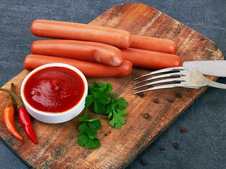 Raw frankfurter sausages with ketchup