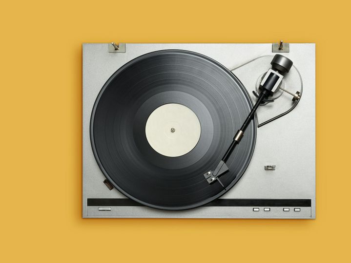 Vinyl player with long play or LP record on yellow background.
