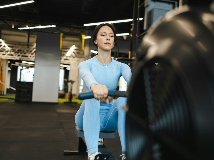 Sporty woman on rowing machine in gym