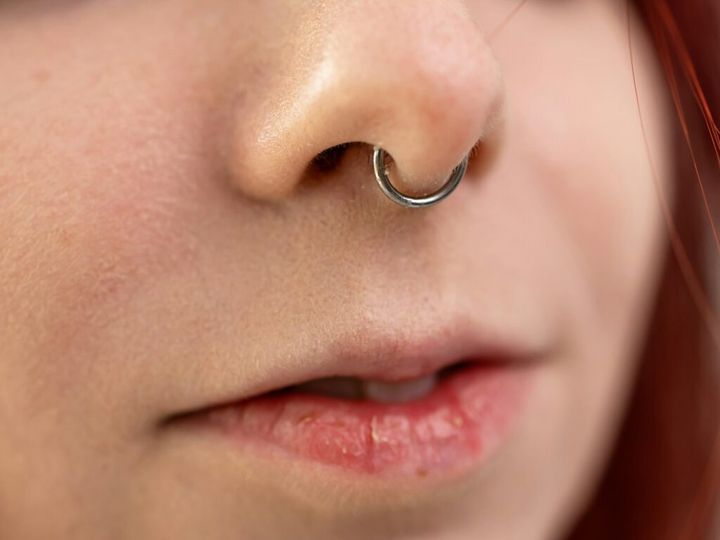 Closeup of a young teen girl's visage with piercing hanging from her nose