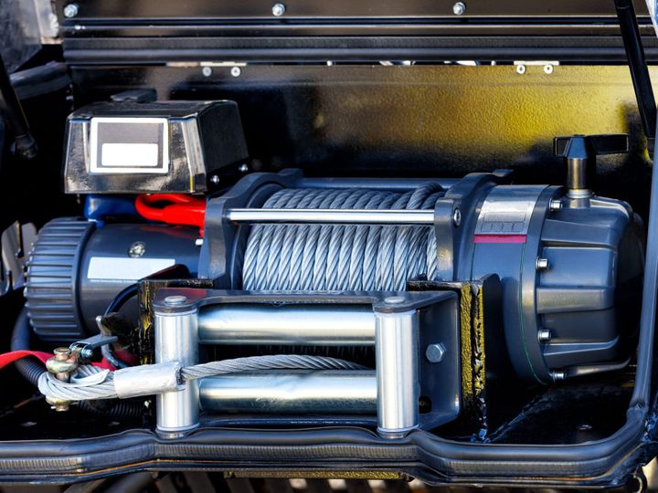 Metallic cable of an electric winch in front of the cargo compartment of an equipped fire truck
