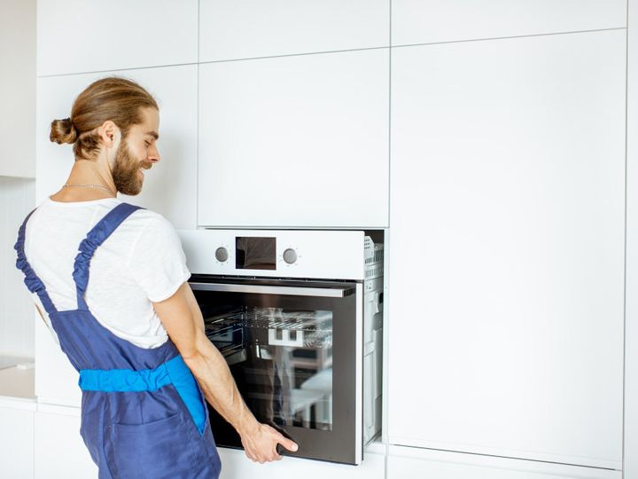 Workman installing kitchen oven