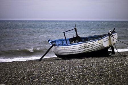 Zakito Posters Plakat 45x30cm Stara łódź rybacka na kamienistej plaży Assaf Frank