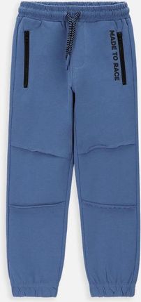 Spodnie dresowe  niebieskie z ozdobnymi przeszyciami o fasonie SLIM